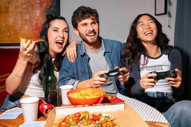 Foto grátis amigos de tom médio a comer pizza.