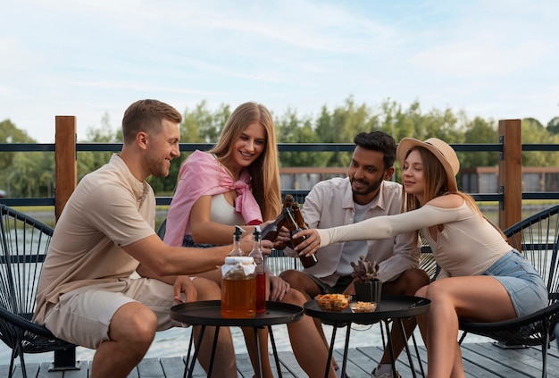 Foto grátis amigos de vista frontal com delicioso kombucha ao ar livre