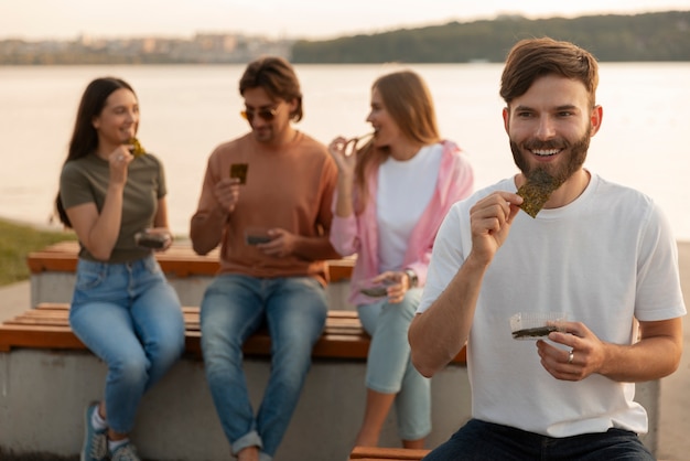 Foto grátis amigos de vista frontal comendo lanches de algas marinhas