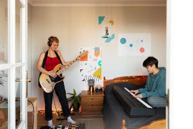 Foto grátis amigos de vista lateral fazendo música em casa