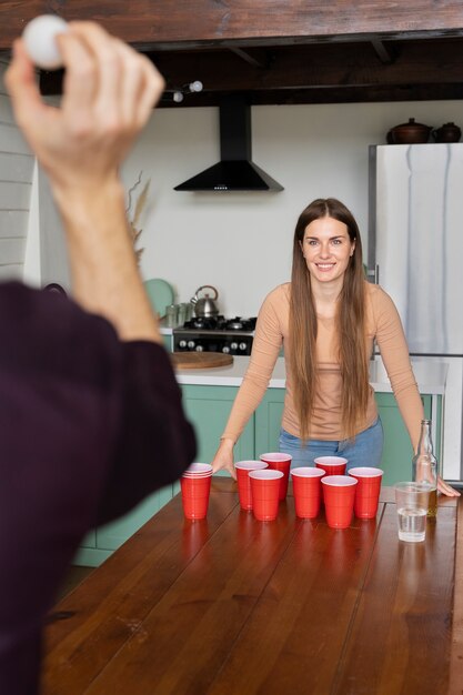 Foto grátis amigos desfrutando de um jogo de beer pong em uma festa coberta