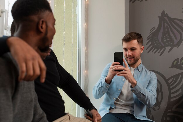 Amigos do sexo masculino de alto ângulo tirando fotos