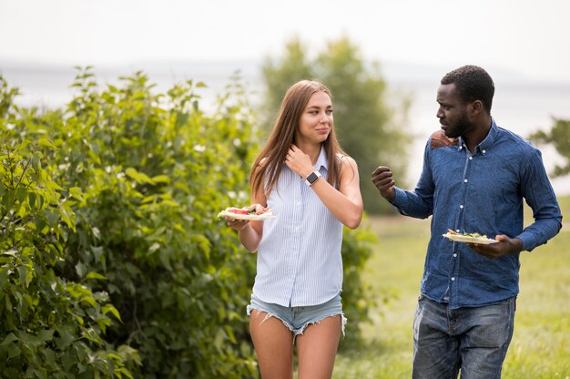 Amigos do sexo masculino e feminino curtindo um churrasco ao ar livre