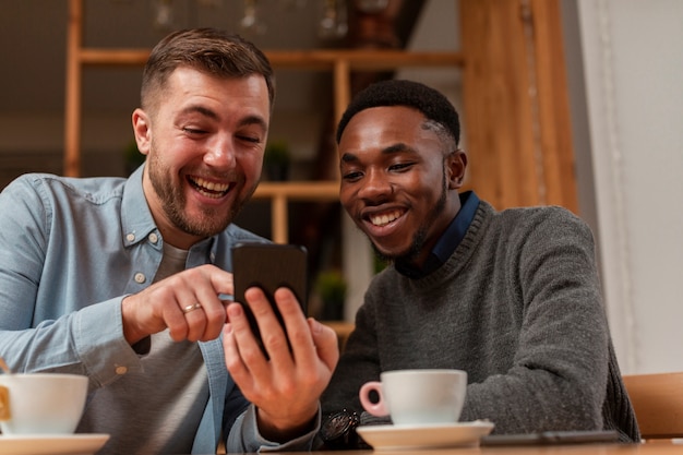 Amigos do sexo masculino jovens procurando no celular