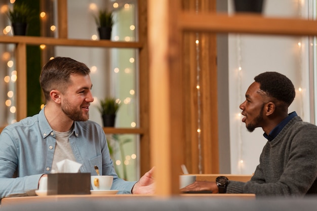 Amigos do sexo masculino que encontram-se no restaurante