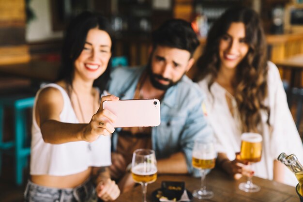 Amigos em bar posando para selfie