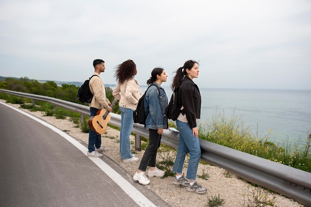 Amigos em filmagem completa olhando para o mar