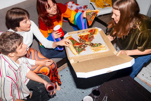 Amigos em uma festa com uma pizza deliciosa