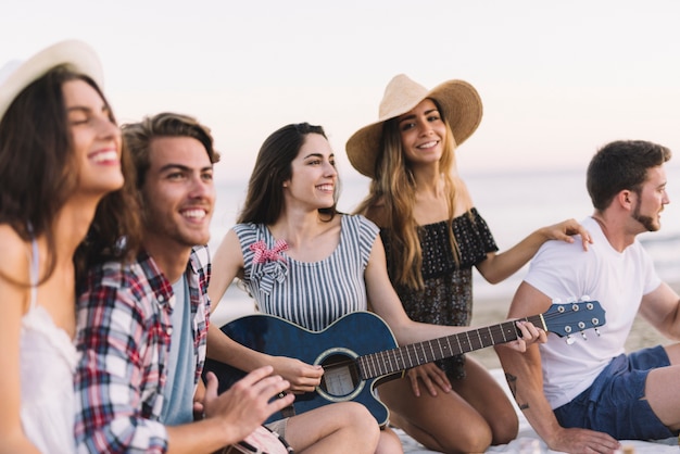 Amigos em uma festa na praia com guitarra