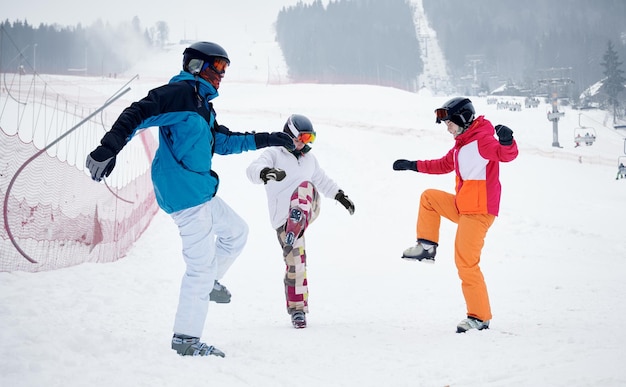 Amigos esquiadores se divertindo na estância de esqui nas montanhas no inverno, esqui e snowboard