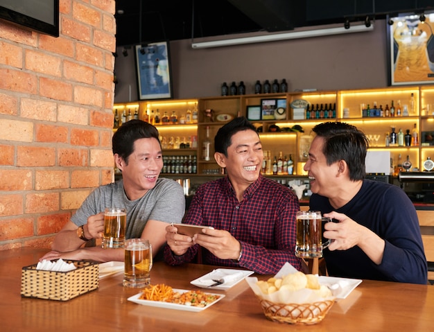 Amigos felizes a passar tempo juntos em um pub de cerveja