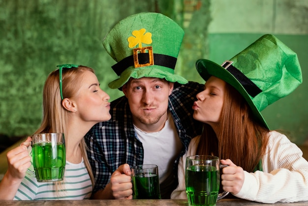 Amigos felizes comemorando juntos st. dia de patrick no bar com bebidas