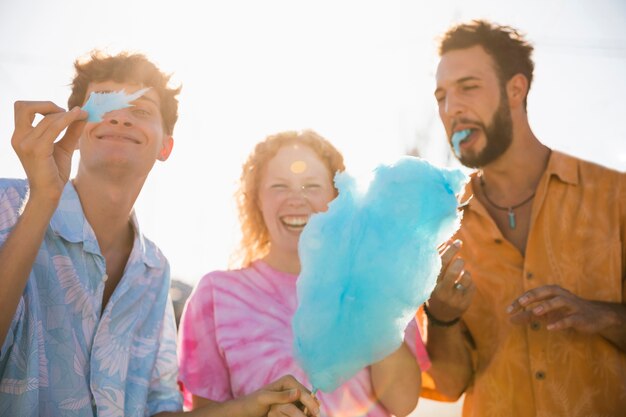 Amigos felizes desfrutando juntos algodão doce