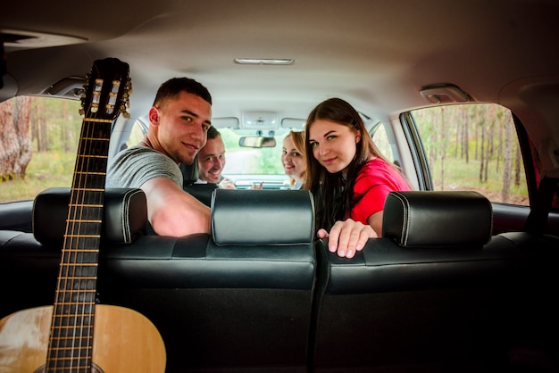 Amigos felizes na vista traseira do carro