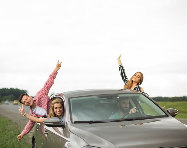 Amigos felizes que apreciam a viagem de carro