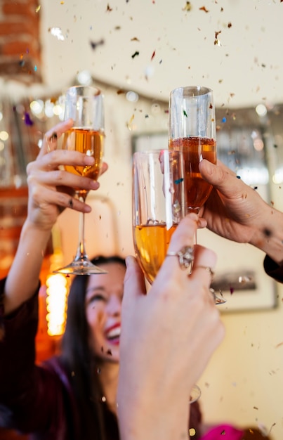 Amigos felizes tilintando copos na festa