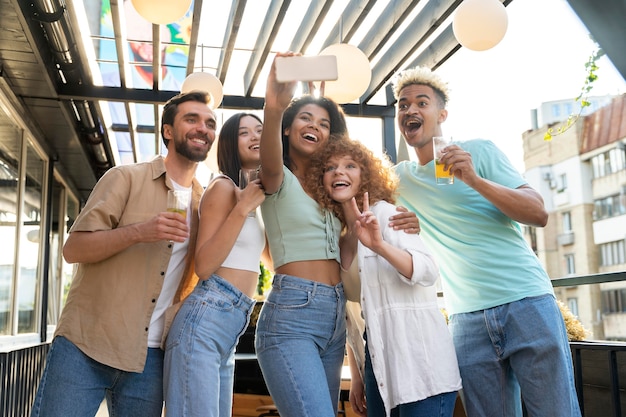 Foto grátis amigos felizes tirando selfie em foto média