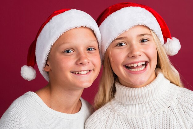Amigos felizes usando chapéus de Papai Noel