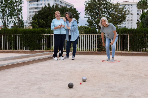 Amigos idosos a jogar petanque.