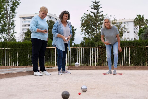 Amigos idosos a jogar petanque.
