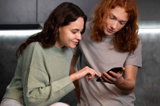 Amigos lendo mensagens de celular plano médio