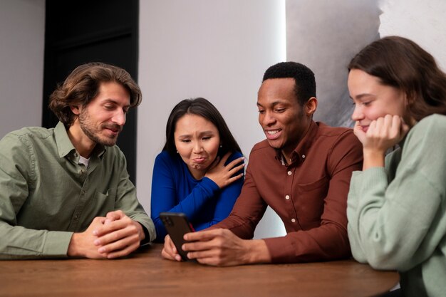 Amigos lendo mensagens de celular plano médio