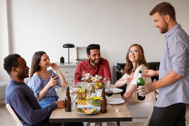 Foto grátis amigos médios atirados num jantar.