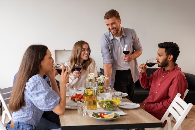 Foto grátis amigos médios atirados num jantar.