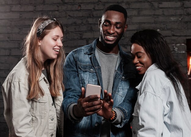 Amigos multirraciais entusiastas, olhando para o telefone