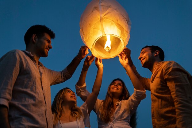 Amigos na praia lançando lanterna durante a noite