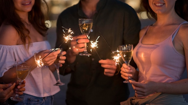 Foto grátis amigos próximos posando com fogos de artifício