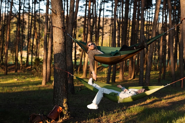 Amigos relaxando em redes, foto completa