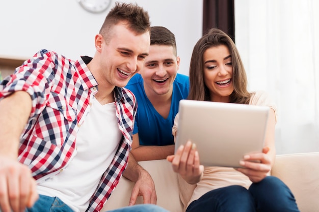 Foto grátis amigos rindo com tablet digital em casa