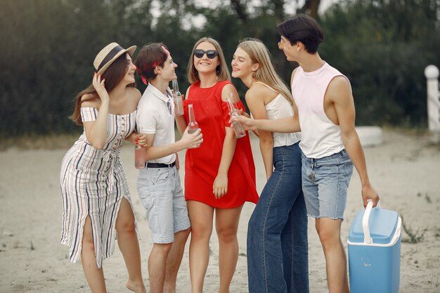 Amigos se divertem na praia com bebidas