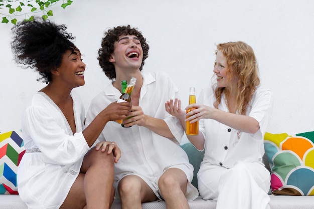 Foto grátis amigos se divertindo com bebidas em uma festa branca