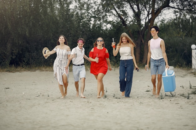 Amigos se divertindo na praia com bebidas