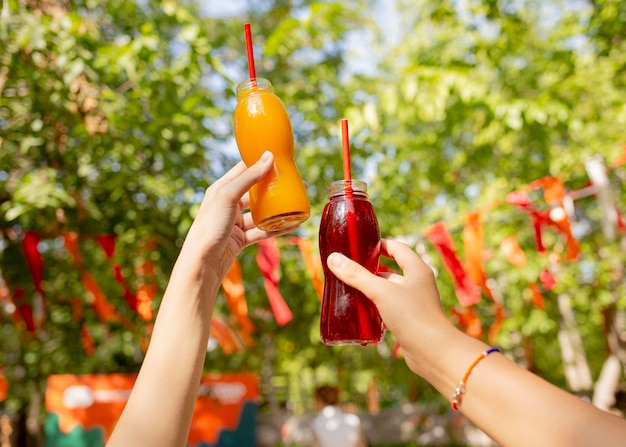 Foto grátis amigos segurando garrafas de suco fresco no parque