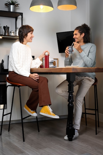 Foto grátis amigos sentados à mesa tiro completo