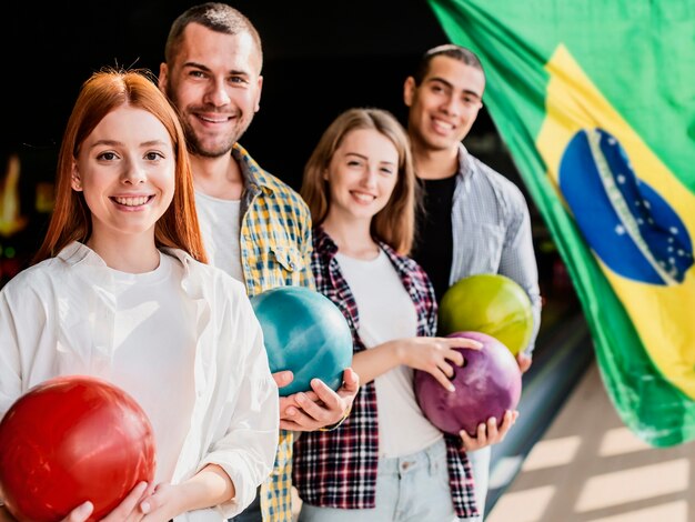 Amigos sorridentes a jogar bowling.