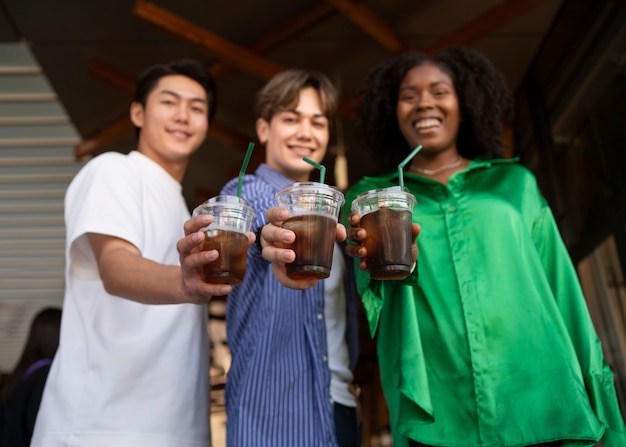 Amigos sorridentes com café gelado baixo ângulo