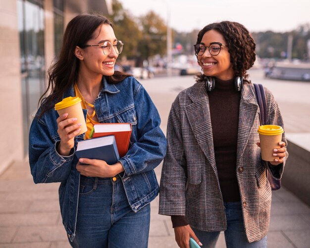 Amigos sorridentes com livros e café