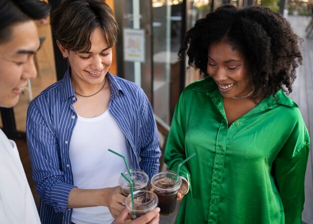 Amigos sorridentes de alto ângulo com café gelado