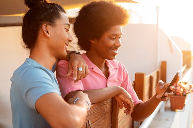 Foto grátis amigos sorridentes de tiro médio ao pôr do sol