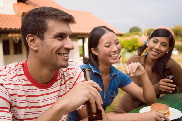 Foto grátis amigos sorridentes de tiro médio com bebidas