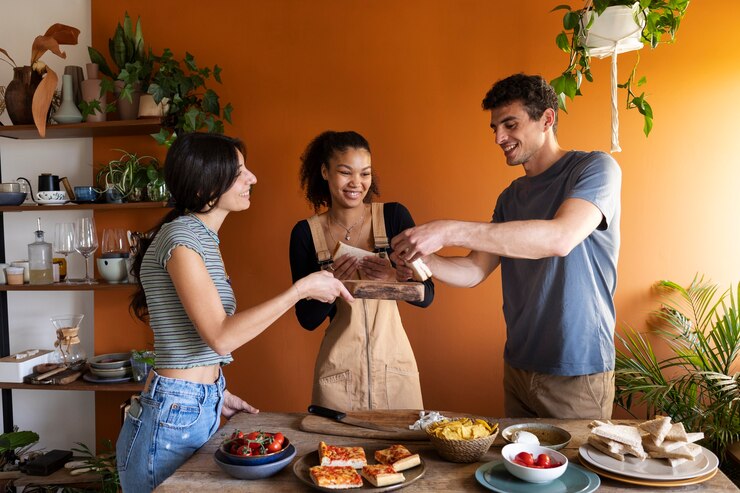 Foto grátis amigos sorridentes de tiro médio com comida deliciosa