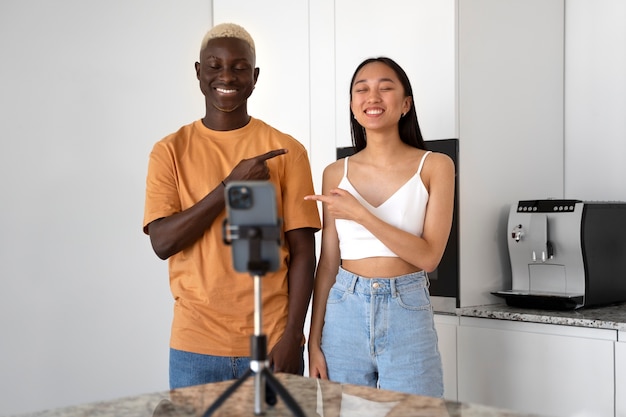 Foto grátis amigos sorridentes de tiro médio gravando vídeo