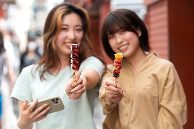 Amigos sorridentes de tiro médio no festival de comida