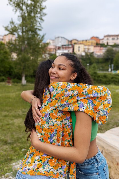 Amigos sorridentes de tiro médio se abraçando