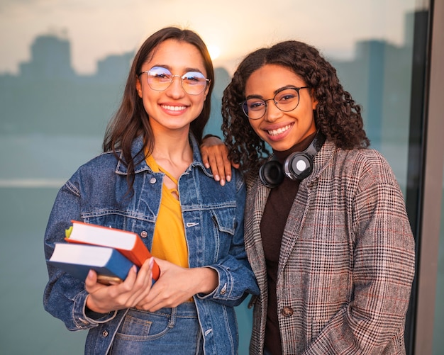 Foto grátis amigos sorridentes posando junto com livros