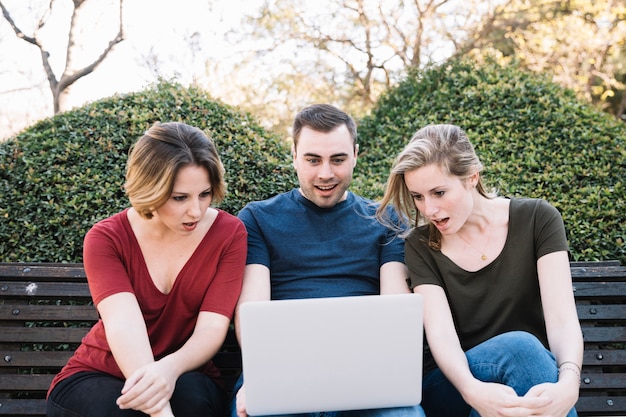 Foto grátis amigos surpreendidos olhando para laptop